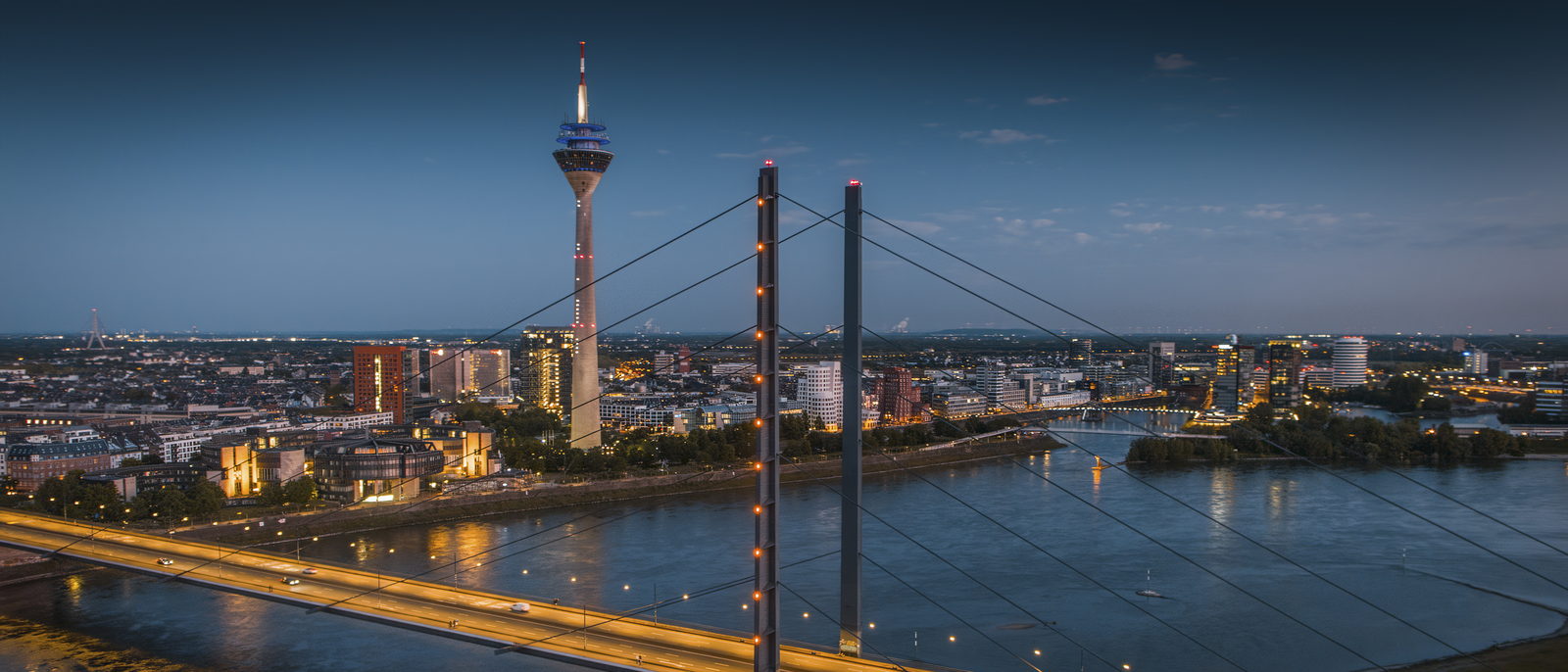 Düsseldorf bei Nacht: Rheinkniebrücke, Rhein und Skyline mit Rheinturm